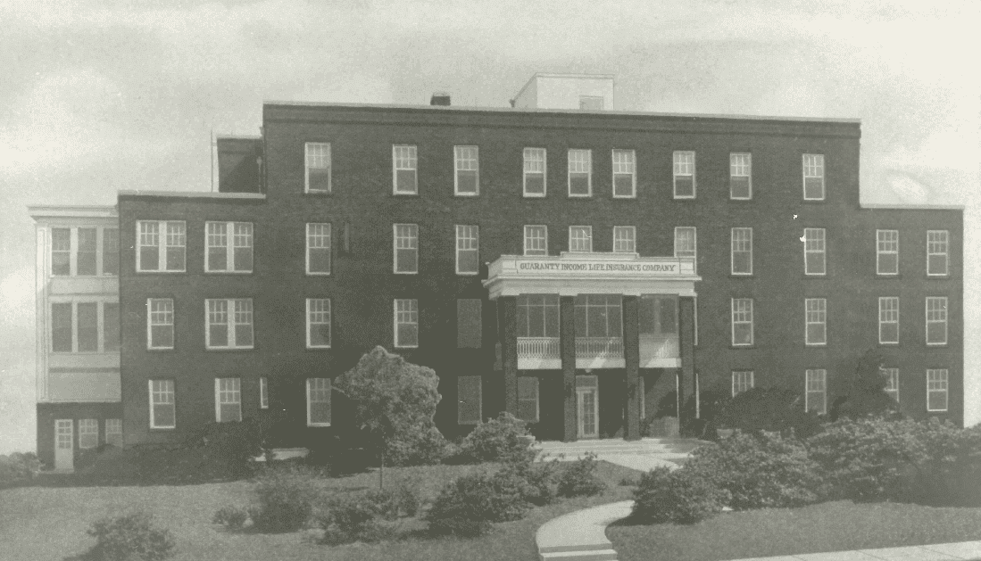 Black and white image of a multi-story brick building with a sign that reads "Charlotte Smelting and Refining Company," tied to George A. Foster Sr.